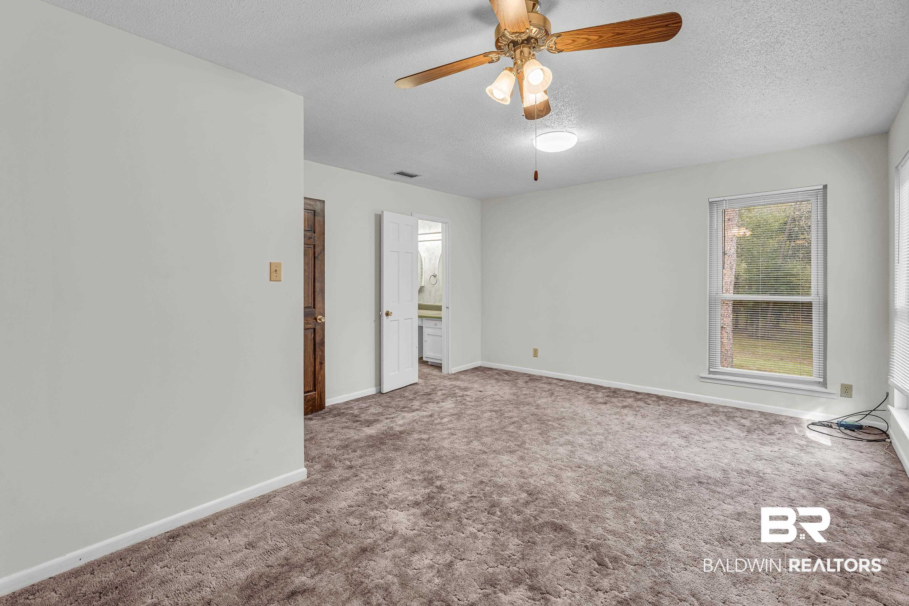 22970 River Road South Daphne, AL 36526 - Photo 41 of 48 Primary Bedroom with ceiling fan, and ensuite bathroom