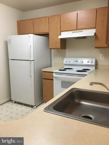 a kitchen with stainless steel appliances a refrigerator a stove a sink and a refrigerator