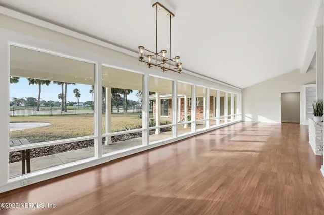 a view of an empty room with a fireplace and a window