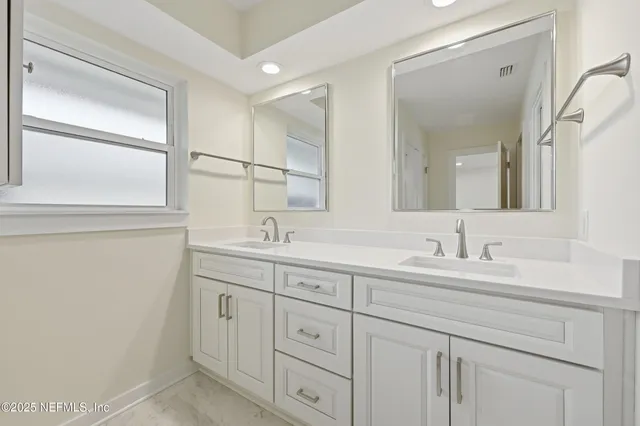 a bathroom with double sink and a mirror