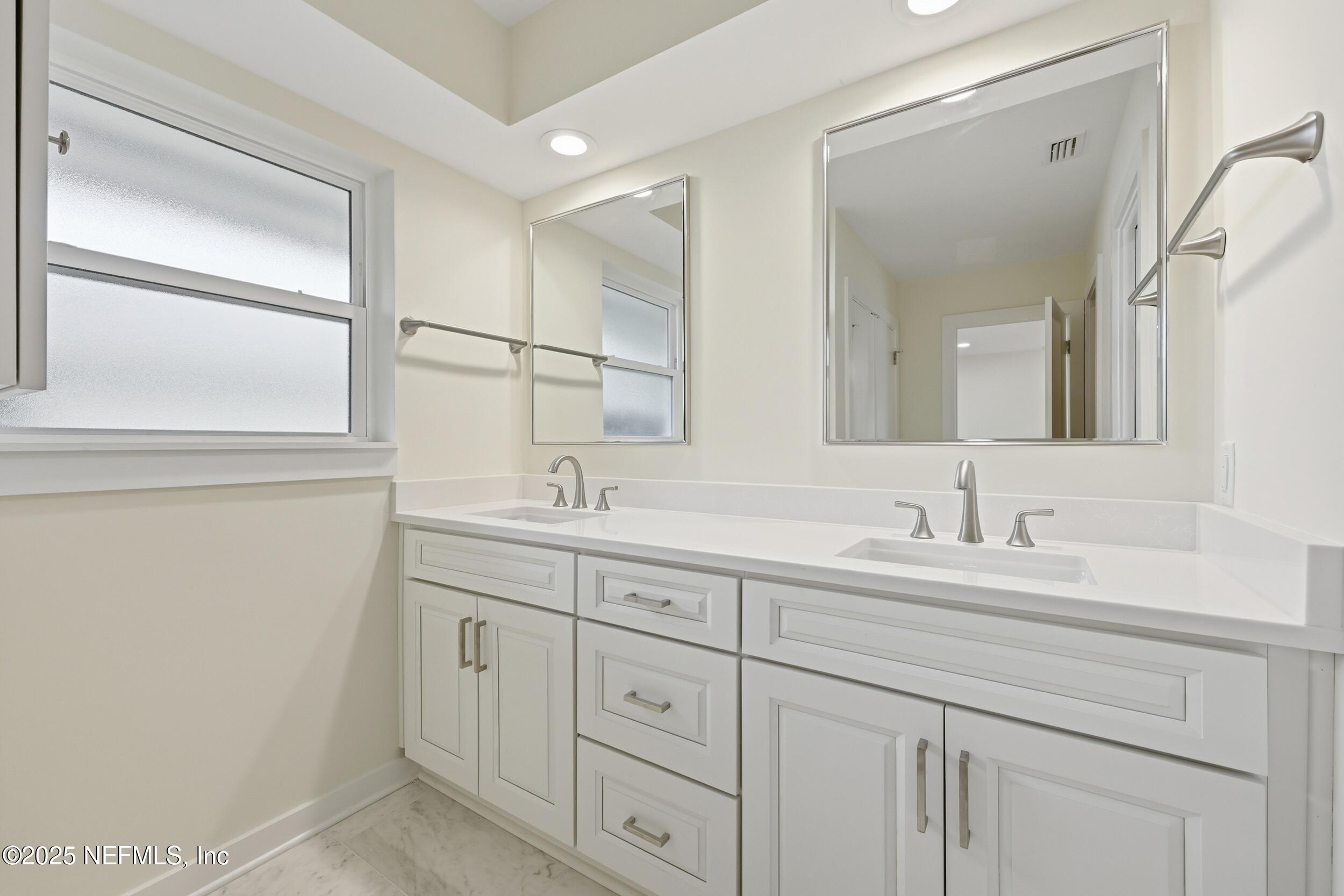 330 San Juan Drive Ponte Vedra Beach, FL 32082 - Photo 18 of 32 a bathroom with a double vanity sink and mirror
