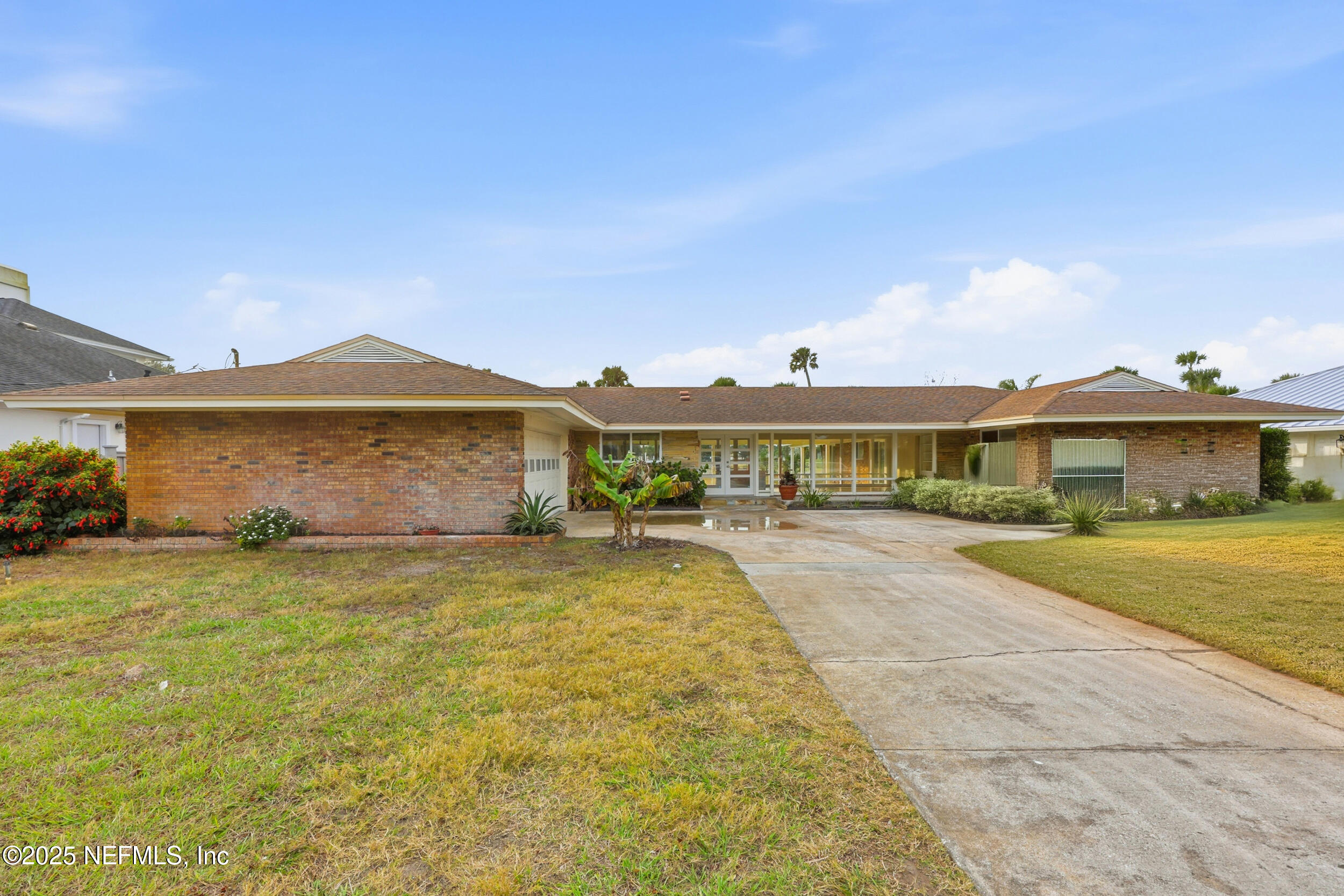 330 San Juan Drive Ponte Vedra Beach, FL 32082 - Photo 2 of 32 a front view of a house with a yard and garage