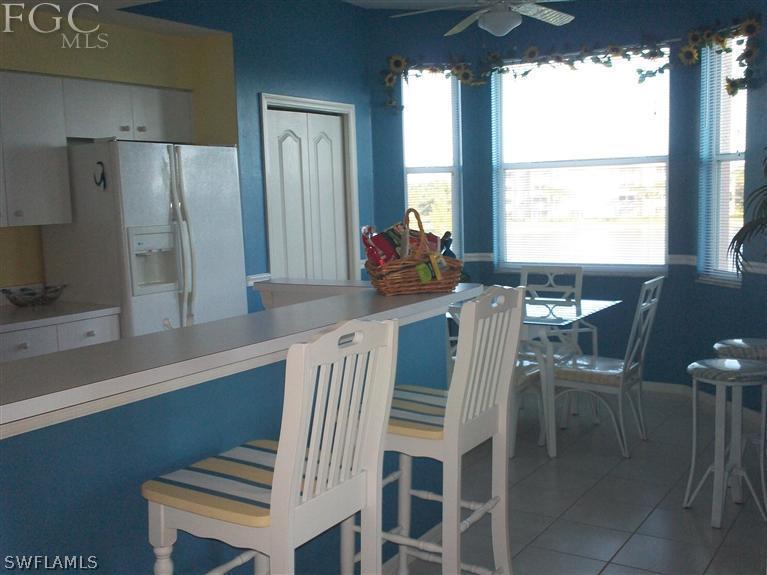 14111 Brant Point Circle, Unit 236 Fort Myers, FL 33919 - Photo 3 of 22 a view of a dining room with furniture a chandelier and wooden floor