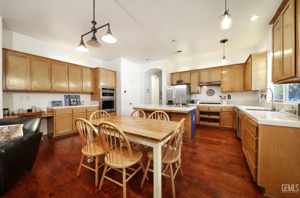 a view of a dining room with furniture a kitchen and chandelier