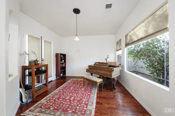 a living room with a piano and a wooden floor