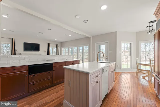 a large white kitchen with a white countertops a dining table and chairs