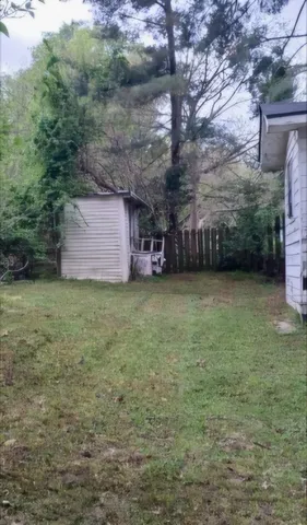 a view of a couches in front of house with yard and trees