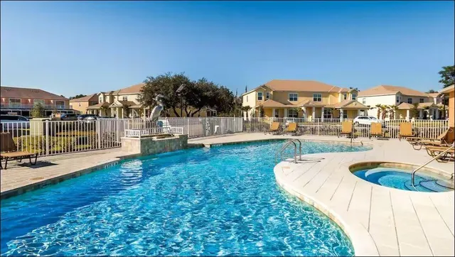 a view of a house with swimming pool and sitting area