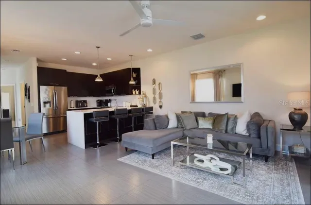 a living room with furniture kitchen view and a refrigerator