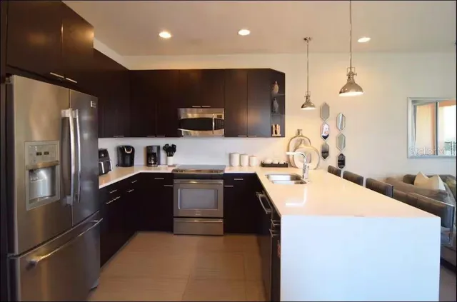 a kitchen with stainless steel appliances kitchen island a sink stove and refrigerator