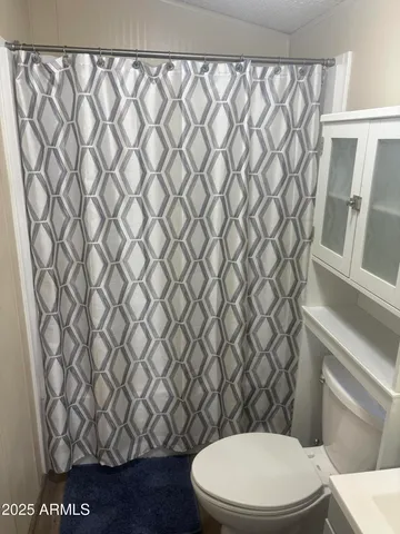 a white toilet sitting next to a white wall