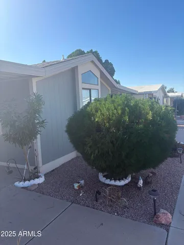 a view of a house with a yard and potted plants