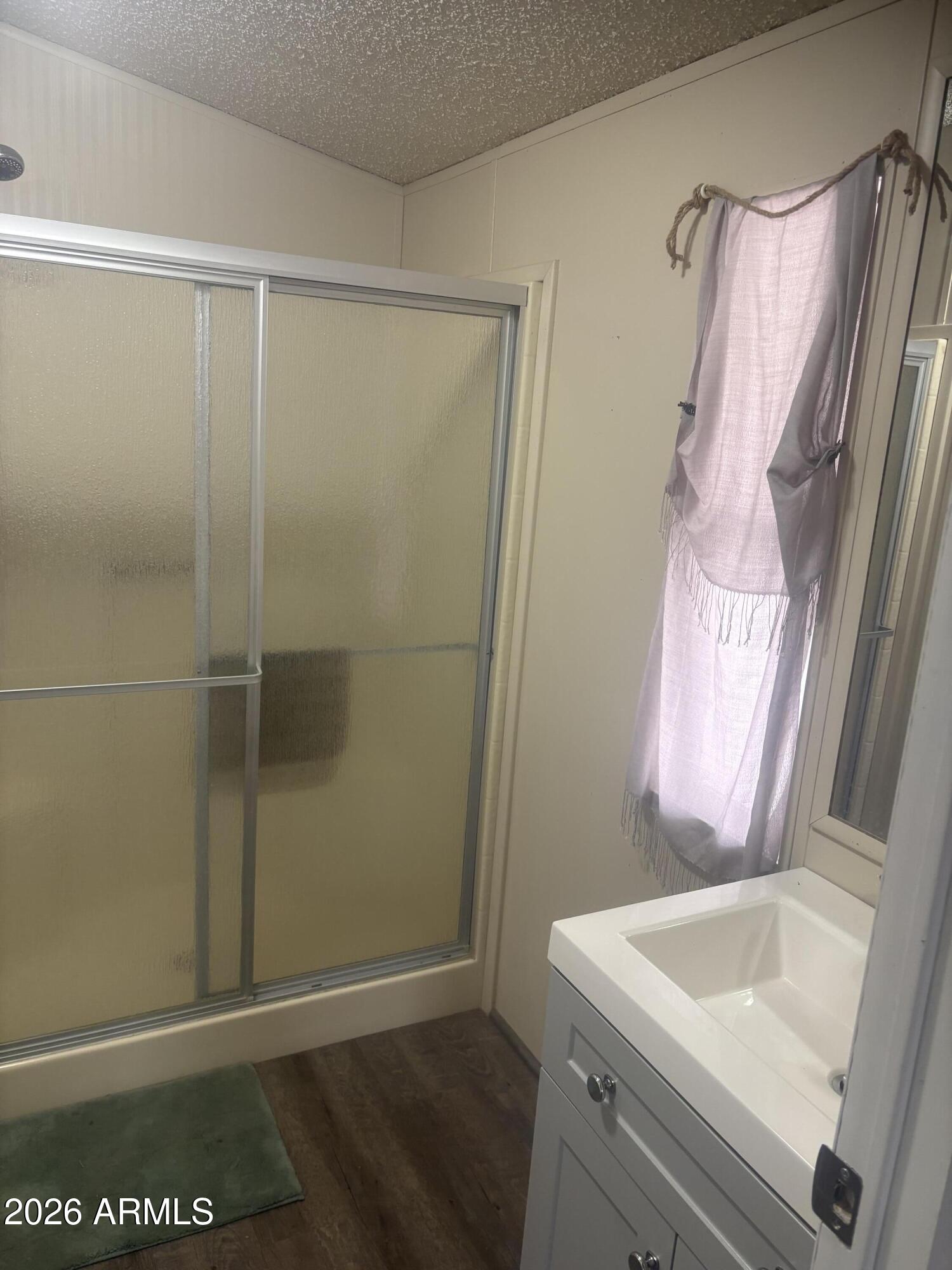 3330 East Main Street, Unit 409 Mesa, AZ 85213 - Photo 26 of 36 a bathroom with a sink a vanity and a shower
