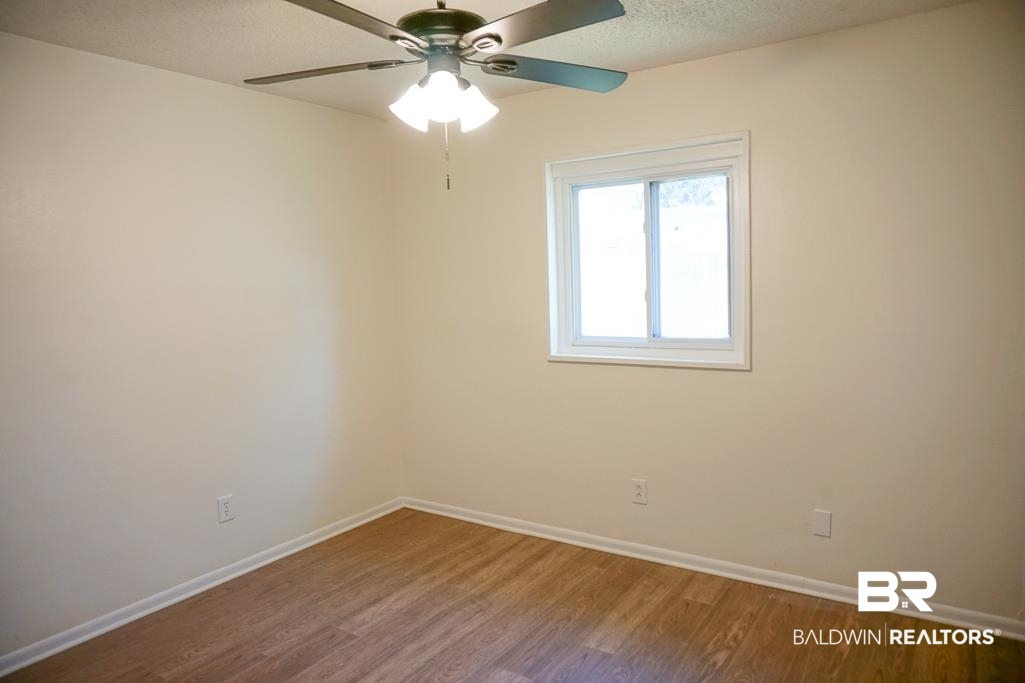 4159 Rebecca Road Mobile, AL 36609 - Photo 18 of 19 Spare room featuring a ceiling fan, a textured ceiling, baseboards, and wood finished floors