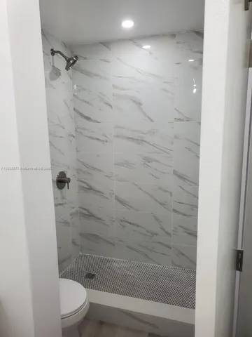 a bathroom with a shower a toilet and sink