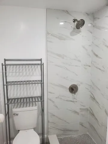 a bathroom with a toilet and a shower