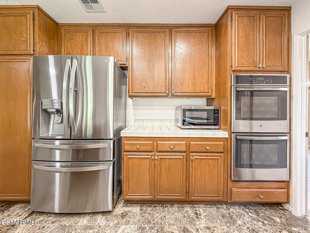 4007 Doneva Road Moorpark, CA 93021 - Photo 11 of 58 a kitchen with stainless steel appliances granite countertop a refrigerator stove and cabinets