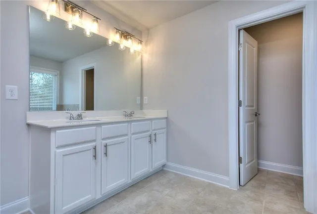 a bathroom with a double vanity sink and a mirror
