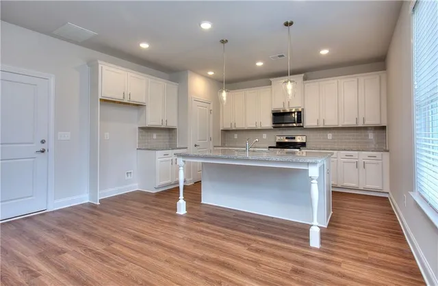 a kitchen with a refrigerator and white cabinets