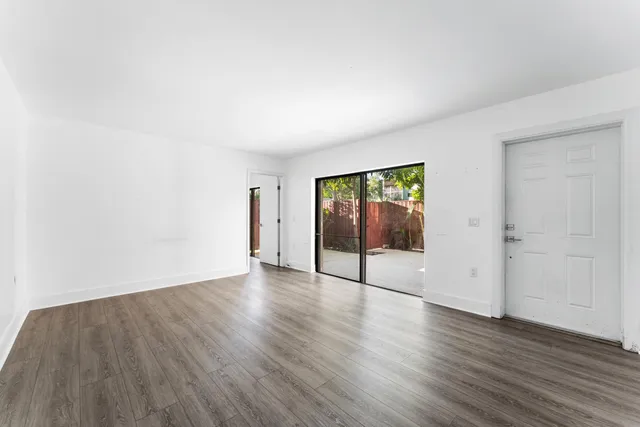 an empty room with wooden floor and white walls