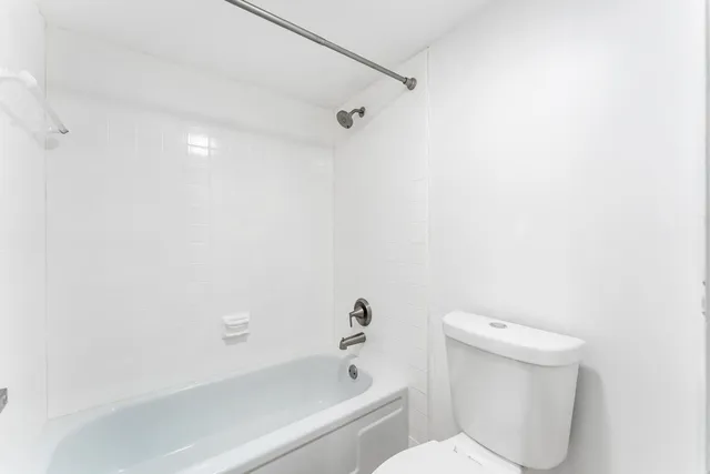 a view of a street with a car parked on the side of the road