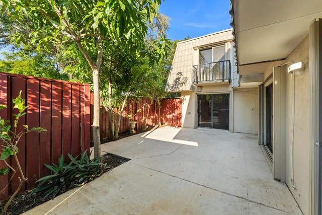 a view of backyard with wooden fence and large trees