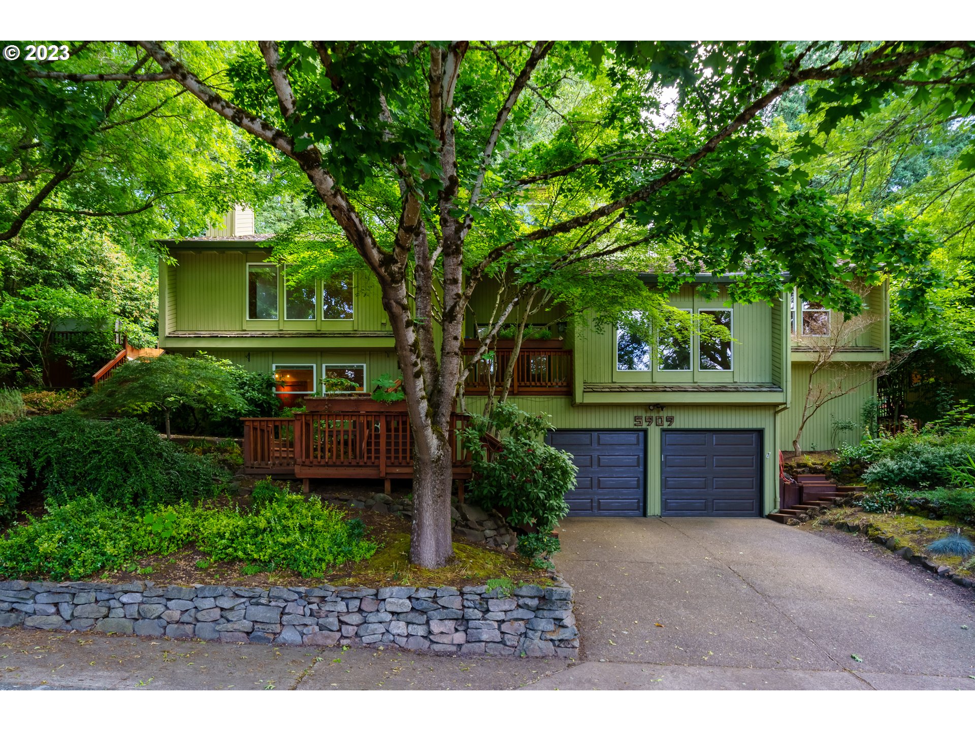 a front view of a house with a yard and a garden