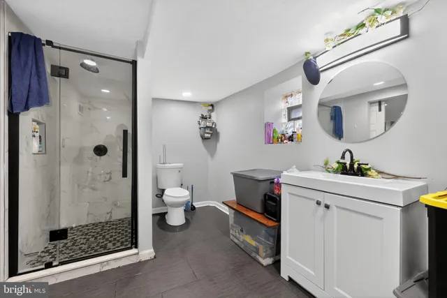 a hall with a toilet a sink and a mirror