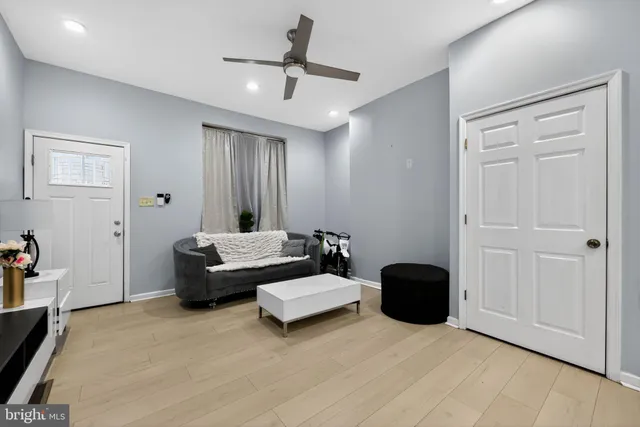 a living room with furniture and a ceiling fan
