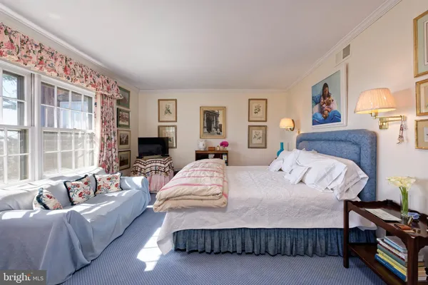 a bedroom with a large bed couch and a window