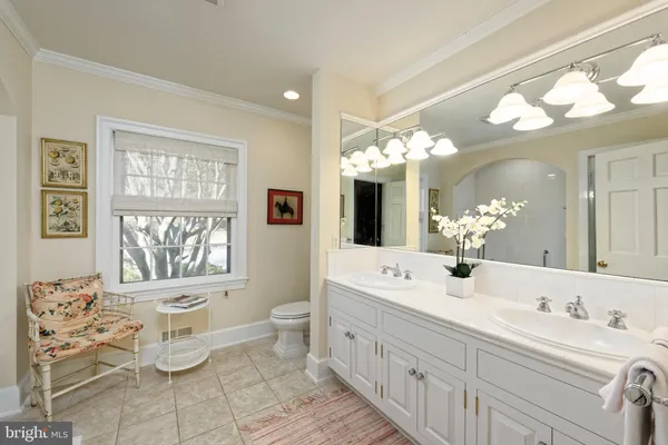 a bathroom with a double vanity sink toilet and a mirror