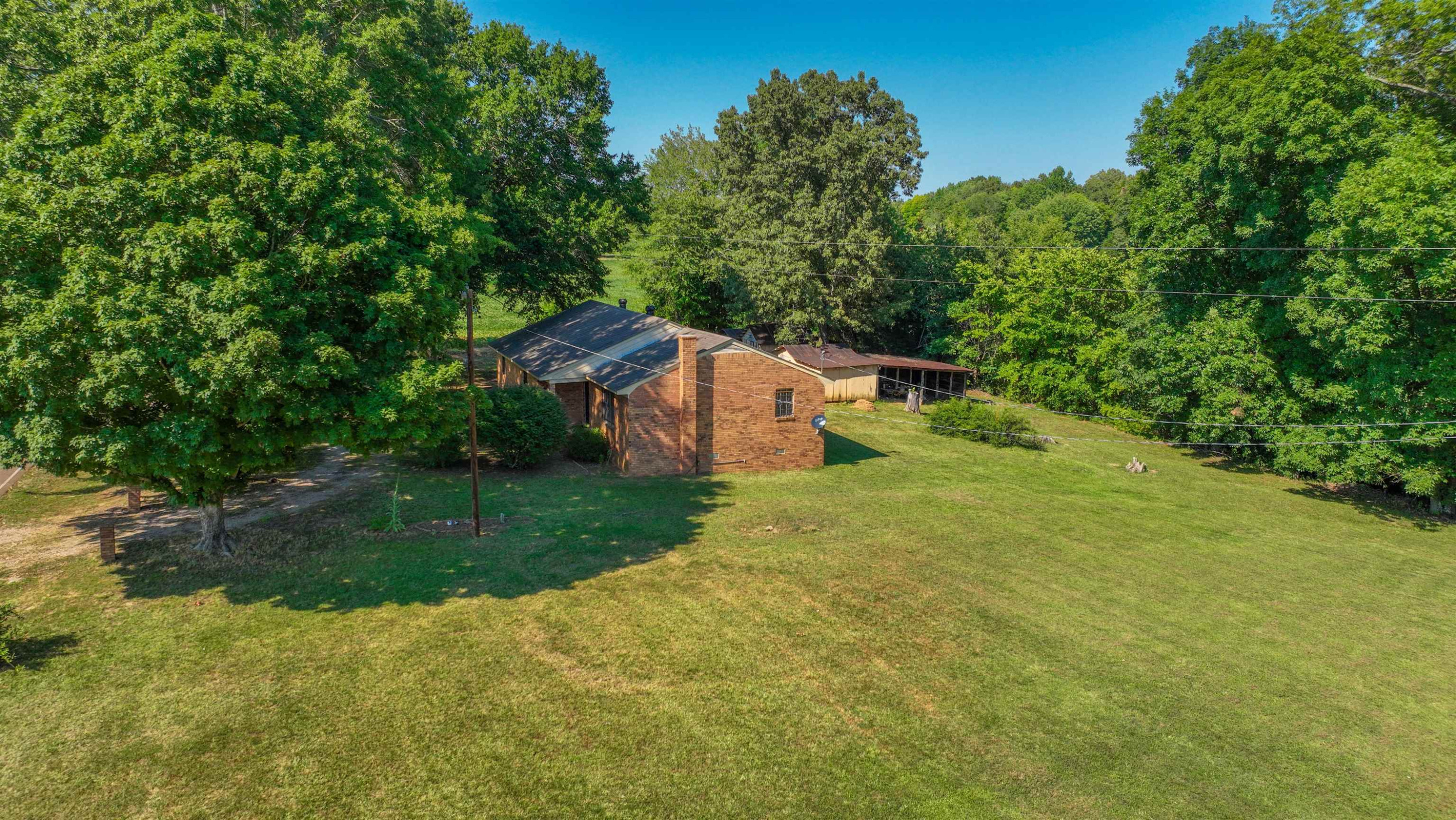 1040 Uptonville Road Mercer, TN 38392 - Photo 15 of 16 a backyard of a house with a garden and deck