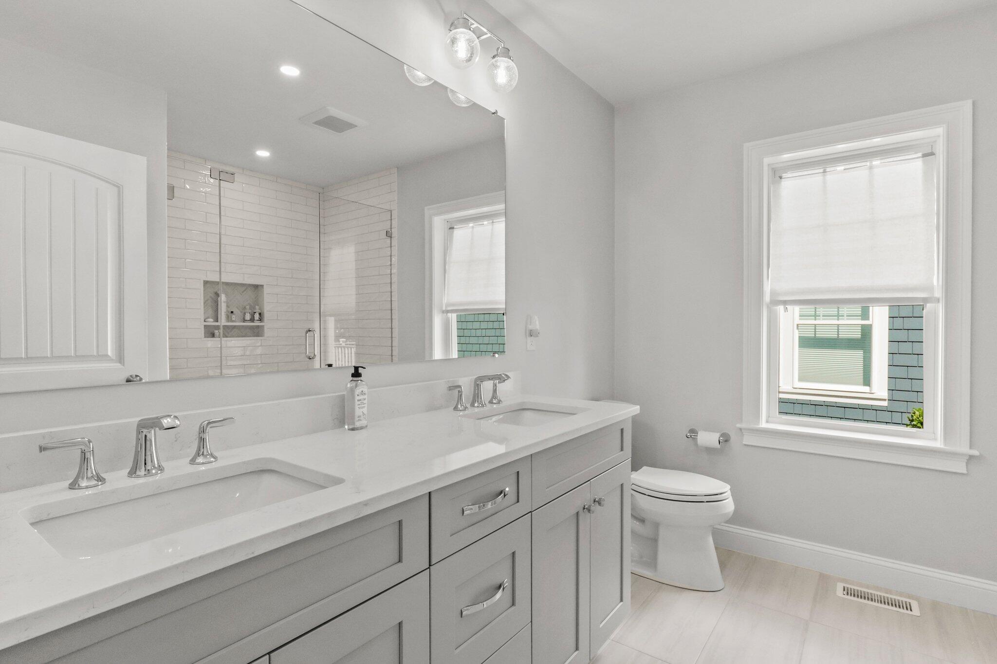 88 Cobblestone Circle Mashpee, MA 02649 - Photo 16 of 49 a bathroom with double vanity sink a mirror and a bathtub