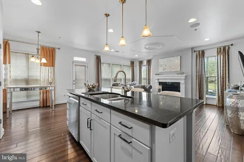 a large kitchen with kitchen island a large island in the center a sink stainless steel appliances and cabinets