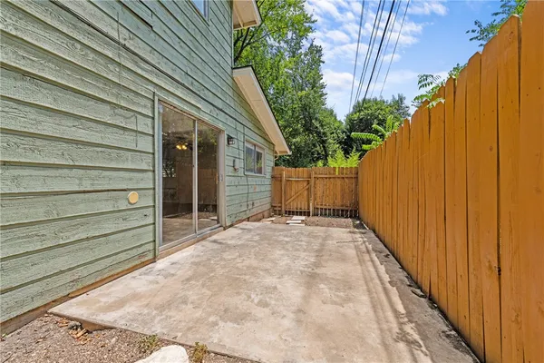 a view of backyard with small cabin and wooden fencing