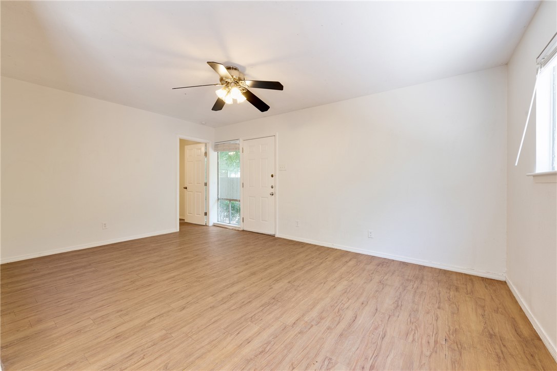 607 East 43rd Street, Unit A Austin, TX 78751 - Photo 6 of 26 an empty room with wooden floor ceiling fan and windows