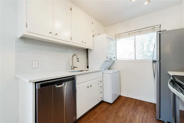 a kitchen with cabinets appliances and a wooden floor