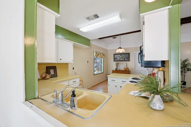 a view of a kitchen with kitchen island a counter top space and a sink