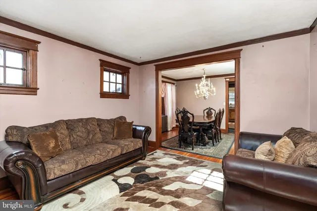 a dining room with furniture a chandelier and wooden floor