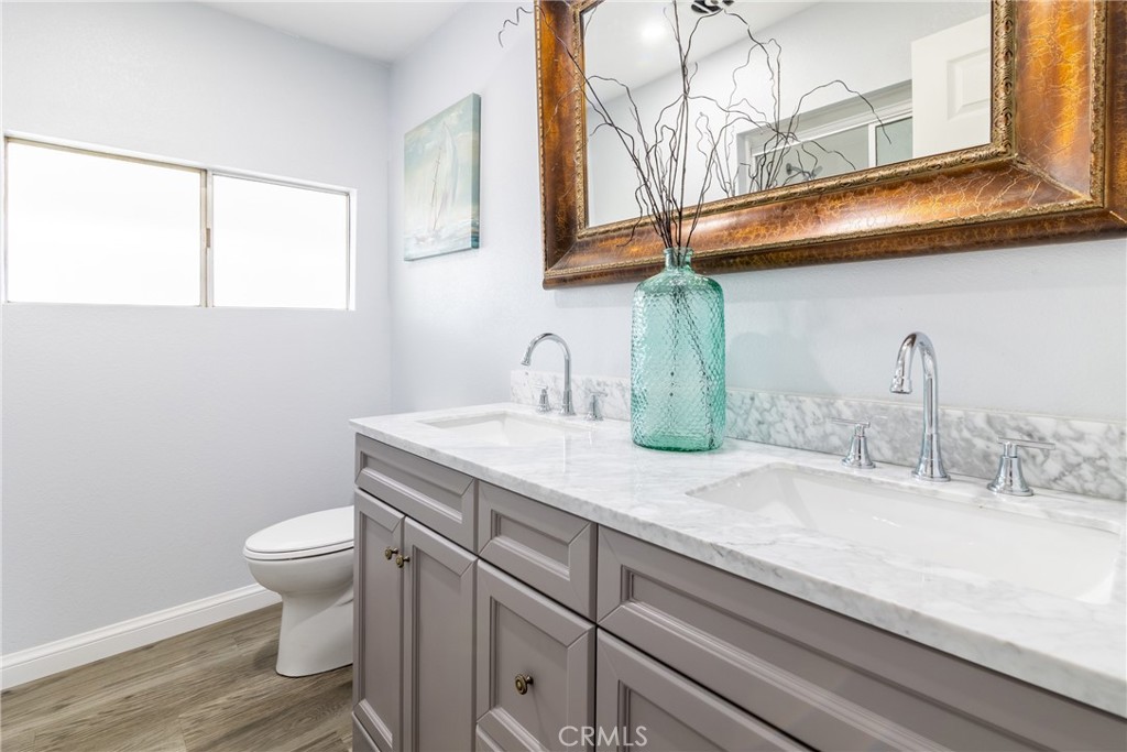 24363 Briggs Road Menifee, CA 92585 - Photo 16 of 43 a bathroom with a granite countertop sink a toilet and a mirror