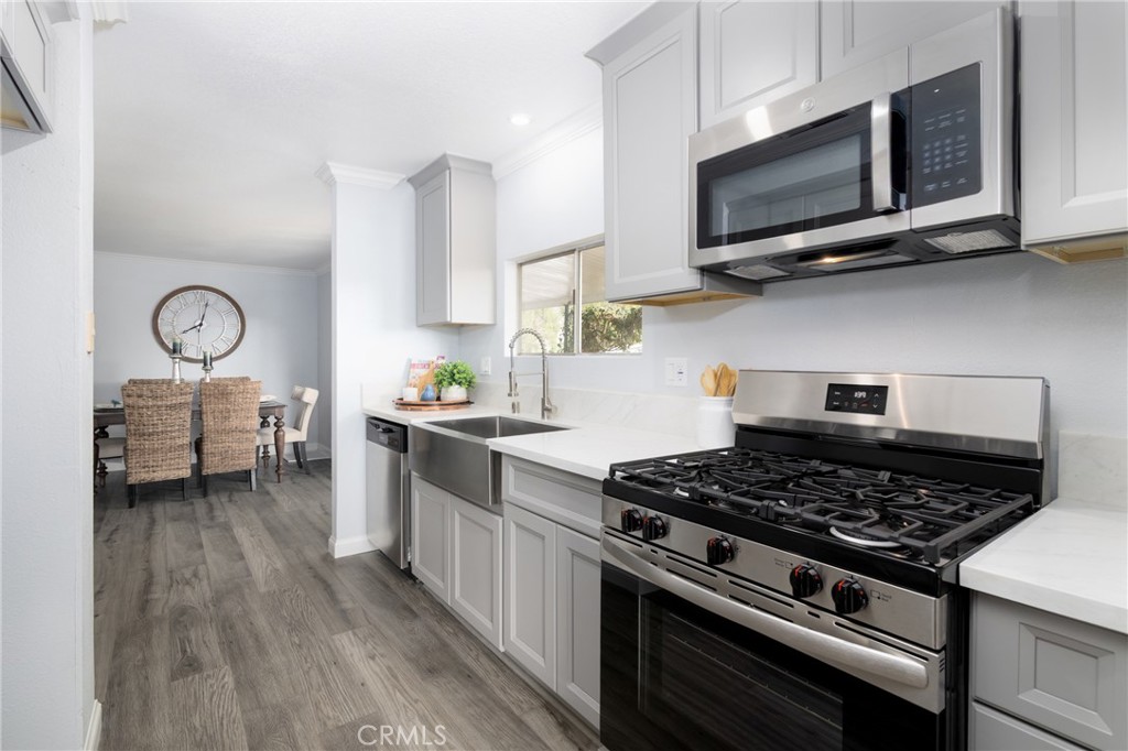 24363 Briggs Road Menifee, CA 92585 - Photo 5 of 43 a kitchen with stainless steel appliances a stove a microwave and cabinets