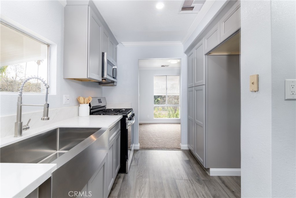 24363 Briggs Road Menifee, CA 92585 - Photo 6 of 43 a kitchen with stainless steel appliances granite countertop a sink a stove and a refrigerator
