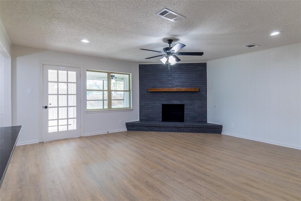 6192 Wrigley Way Fort Worth, TX 76133 - Photo 11 of 22 an empty room with windows chandelier and fireplace