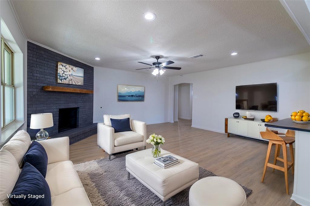 6192 Wrigley Way Fort Worth, TX 76133 - Photo 3 of 22 a living room with furniture a flat screen tv and a fireplace