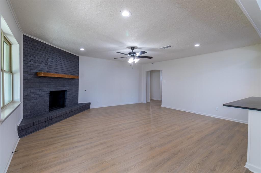 6192 Wrigley Way Fort Worth, TX 76133 - Photo 4 of 22 a view of an empty room with a fireplace and a window