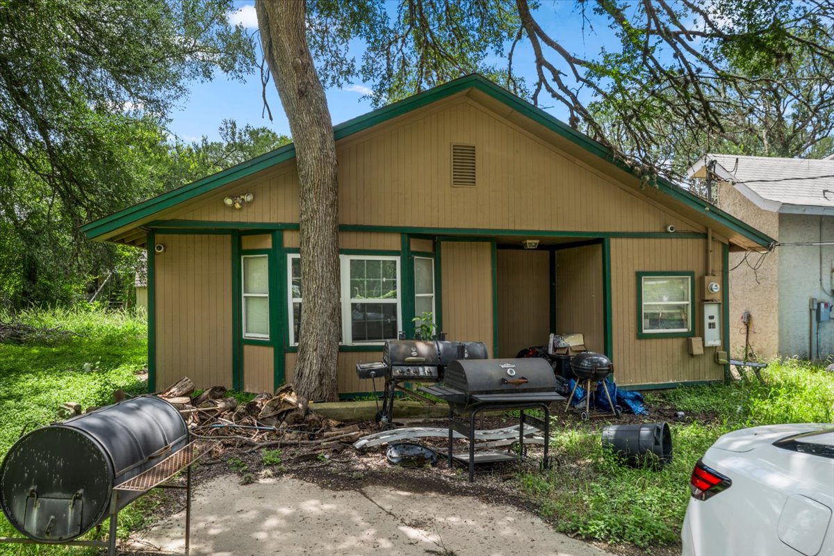 151 High Ridge Drive Del Valle, TX 78617 - Photo 2 of 8 A modest tan and green exterior blends into the lush, treed surroundings.