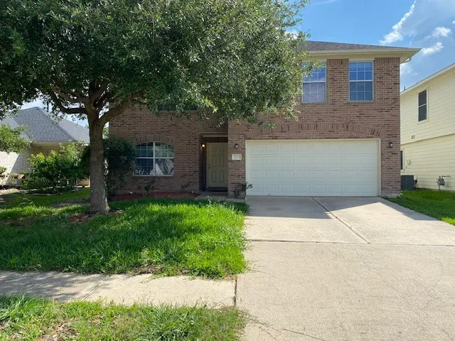 a front view of a house with a garden and trees
