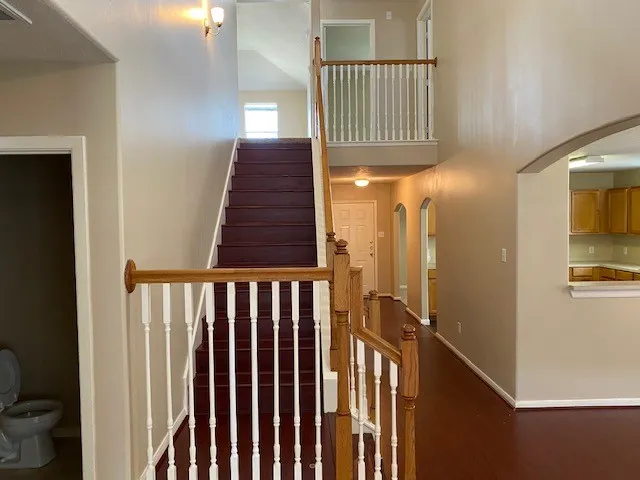 a view of staircase with railing and a window