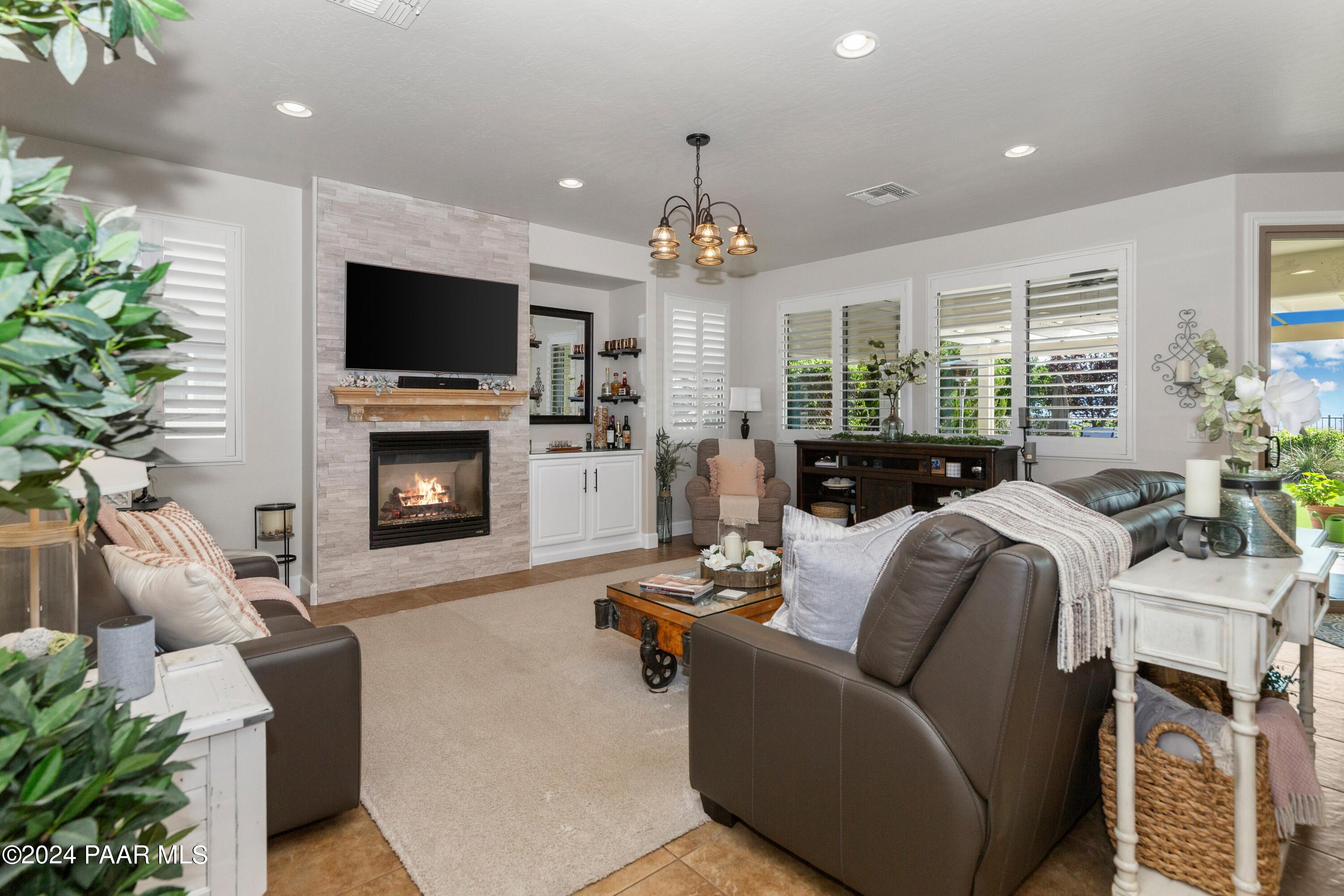 1219 Stack Rock Road Prescott Valley, AZ 86314 - Photo 14 of 41 a living room with furniture a flat screen tv and a fireplace