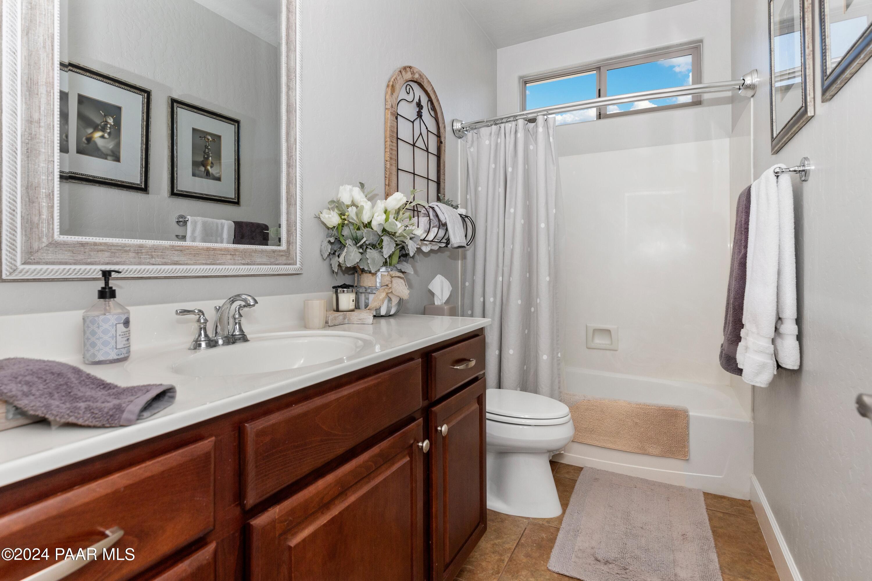 1219 Stack Rock Road Prescott Valley, AZ 86314 - Photo 23 of 41 a bathroom with a granite countertop sink a toilet a mirror and shower